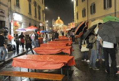 Una delle tavolate rovinate dal tempo; a destra volontari del soccorso 