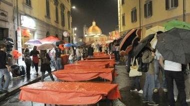 Una delle tavolate rovinate dal tempo; a destra volontari del soccorso
