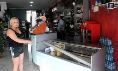 Il bar Mony con la vetrina rotta e sotto la titolare Monica Padulo    