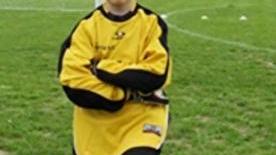 Il piccolo Matteo mentre posa felice sul campo di calcio di S. Vincenzo nella sua divisa da portiere