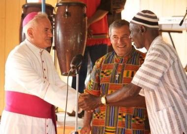 Padre Mario al centro riceve la targa di cavaliere 