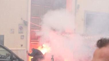 Un manifestante lancia un fumogeno contro la sede di Confindustria in via Roma