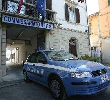 Una pattuglia della polizia in uscita dal commissariato e, accanto, una prostituta in attesa di clienti  