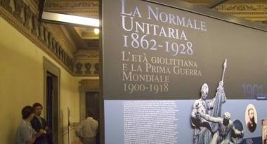 A destra una sezione della mostra al palazzo della Carovana e la visita di Rossi accompagnato da Settis. Sotto Luigi Russo alla Normale nel 1944 e il decreto napoleonico che istituiva la Scuola 