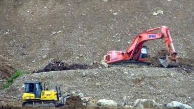 Una ruspa al lavoro per realizzare la discarica