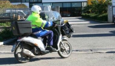 <strong>A LAVORO.</strong> Portalettere in scooter durante la consegna A destra impiegati agli sportelli servono i clienti