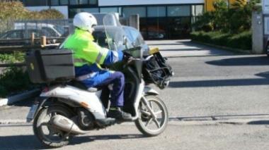 <strong>A LAVORO.</strong> Portalettere in scooter durante la consegna A destra impiegati agli sportelli servono i clienti