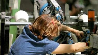 Un’operaia al lavoro in una tessitura