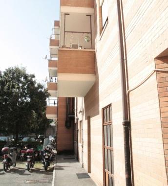 Il balcone dal quale &egrave; caduta Monica Di Martino e, pi&ugrave; a destra, una volante della polizia nel cortile del condominio   