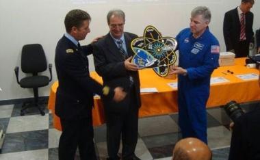 Gli astronauti Roberto Vittori e Greg Johnson consegnano a Valfredo Zolesi il simbolo della missione