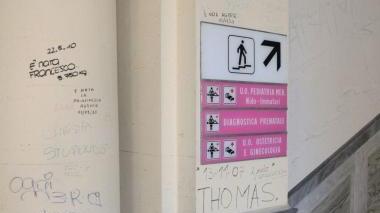 Da sinistra, scritte sulla finestra e all’ingresso delle scale che portano al reparto. A sinistra l’ascensore imbrattato e sopra si vedono le scritte anche sull’affresco