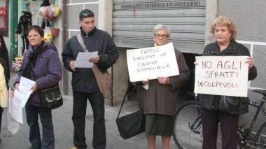 A destra, la famiglia sfrattata dentro l’alloggio; a sinistra, il picchetto sotto la casa da sgomberare in piazza Cavallotti