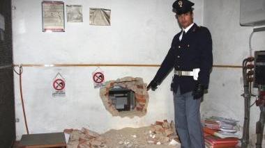 Un agente mostra il buco realizzato dai rapinatori
