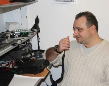 Radioamatore intento a parlare al microfono della sua attrezzatura   
