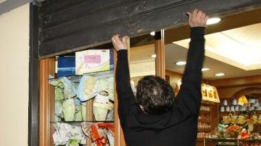<b>LE BOTTEGHE RESISTONO. </b> Un commerciante alza la saracinesca del proprio negozio