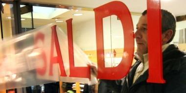 <b>IL COMMERCIO IN DIFFICOLT&Agrave;.</b> Un negoziante applica alla vetrina ladesivo che annuncia il via ai saldi 