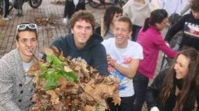 I ragazzi raccolgono le foglie nel giardino della scuola