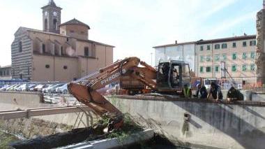 A sinistra, le ruspe in azione sul diaframma tra i due spezzoni di canale; in alto, l’acqua che inizia a filtrare; a destra, gente sulle spallette che osserva i lavori