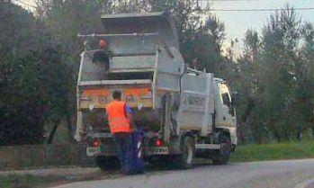 Un camion svuota il bidone blu per la plastica   