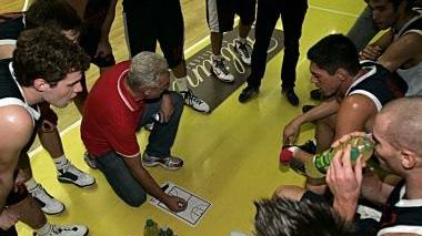 Coach Massimo Angelucci illustra i suoi schemi ai giocatori rossoblù e, a destra, una conclusione da sotto canestro di Gabriele Niccolai
