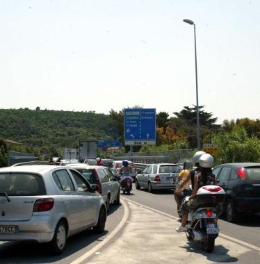 Sotto Cosimi e Nocchi A destra lAurelia nel tratto dello svincolo del Maroccone presa dassalto da auto, moto e scooter in una giornata estiva  