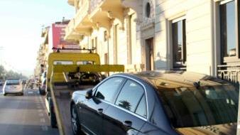 Un carro attrezzi rimuove un’auto in sosta