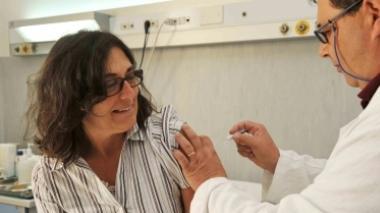 Un medico somministra a una paziente il vaccino contro l’influenza