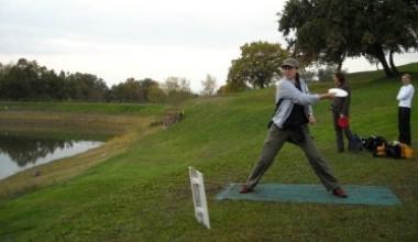 Una praticante di Disc Golf in azione: il disco, simile a un frisbee, deve essere lanciato in un canestro 