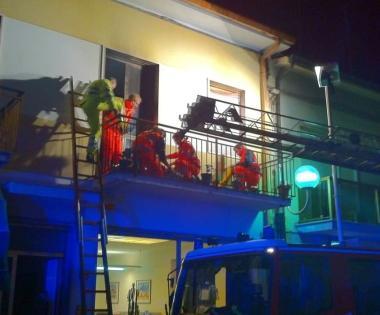 La donna sul balcone della casa in fiamme durante i soccorsi 
