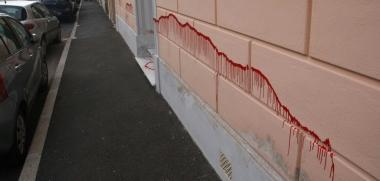 <strong>ATTO VANDALICO O DISPETTO? </strong>La striscia di vernice rossa corre per metri lungo il muro, poi comprende il portone e un altro tratto di parete esterna