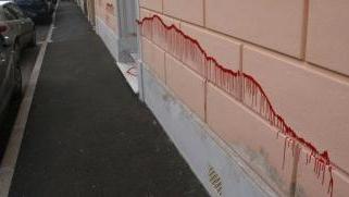<strong>ATTO VANDALICO O DISPETTO? </strong>La striscia di vernice rossa corre per metri lungo il muro, poi comprende il portone e un altro tratto di parete esterna