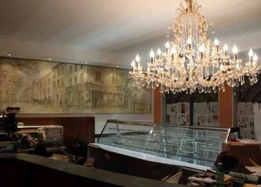 <strong>L’INTERNO.</strong> Due immagini del bancone del bar e del grande affresco che ritrae piazza Aranci ai primi del Novecento