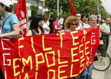 Manifestazione sindacale e a destra lavoratori fuori dalla fabbrica