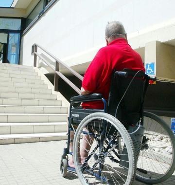 Un disabile in carrozzina di fronte a una scalinata