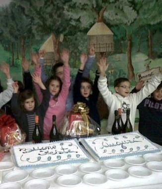 Bambini in festa davanti alla torta per don Pietro 