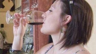 Una ragazza gusta un buon bicchiere di vino