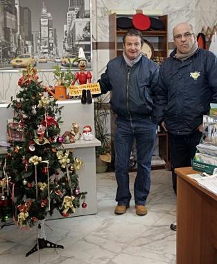I due tassisti nel punto informazioni della stazione di Pescia accanto al loro alberino di Natale      