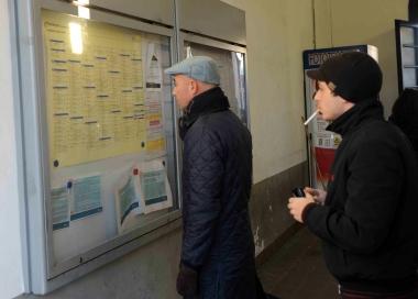 Viaggiatori davanti ai nuovi orari dei treni a Pontedera 
