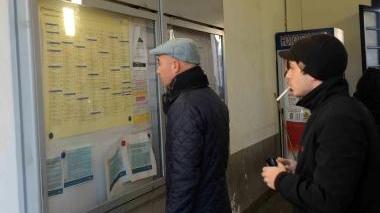 Viaggiatori davanti ai nuovi orari dei treni a Pontedera
