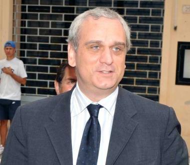 Gli operai della Eaton chiusi dietro i cancelli della fabbrica. A sinistra il sottosegretario Stefano Saglia 