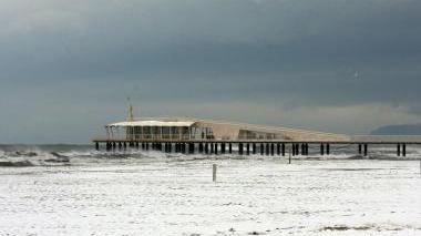 In bicicletta tra la neve in centro a Camaiore e sopra le auto imbiancate davanti allo stadio comunale di Camaiore. Al centro la neve in Passeggiata a Lido e la spiaggia con il pontile