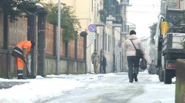 Un operaio del Comune cerca di liberare un marciapiede dal ghiaccio nel centro di Pontedera
