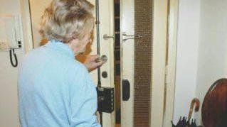 Un’anziana apre la porta di casa