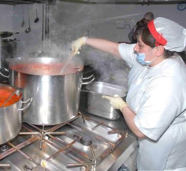Una cuoca al lavoro (foto archivio) 