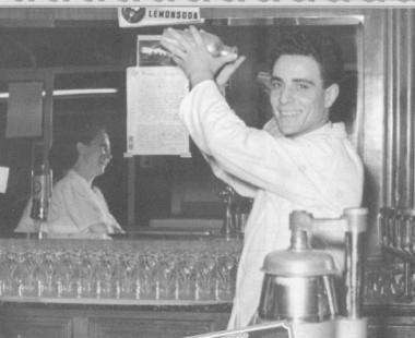 Un barista daltri tempi mentre prepara una bevanda shakerata      