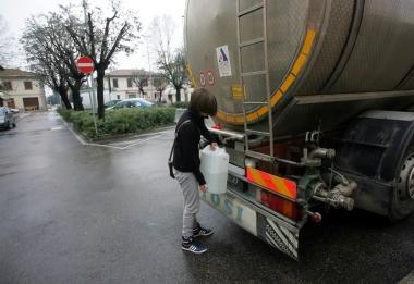 Una ragazza fa rifornimento d’acqua all’autobotte di San Pierino
