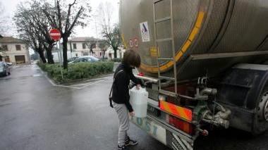 Una ragazza fa rifornimento d’acqua all’autobotte di San Pierino