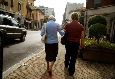 Una badante accompagna a passeggio unanziana  