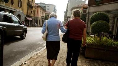 Una badante accompagna a passeggio un’anziana