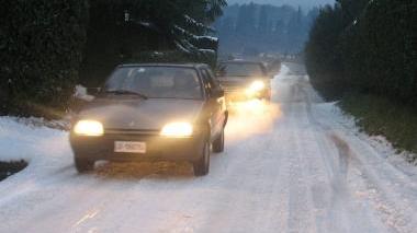 Auto a passo d’uomo su una strada innevata